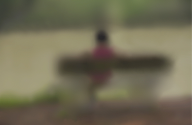 Completely blurry image of a person sitting on a bench