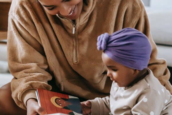 Image of young mother reading a book to her infant