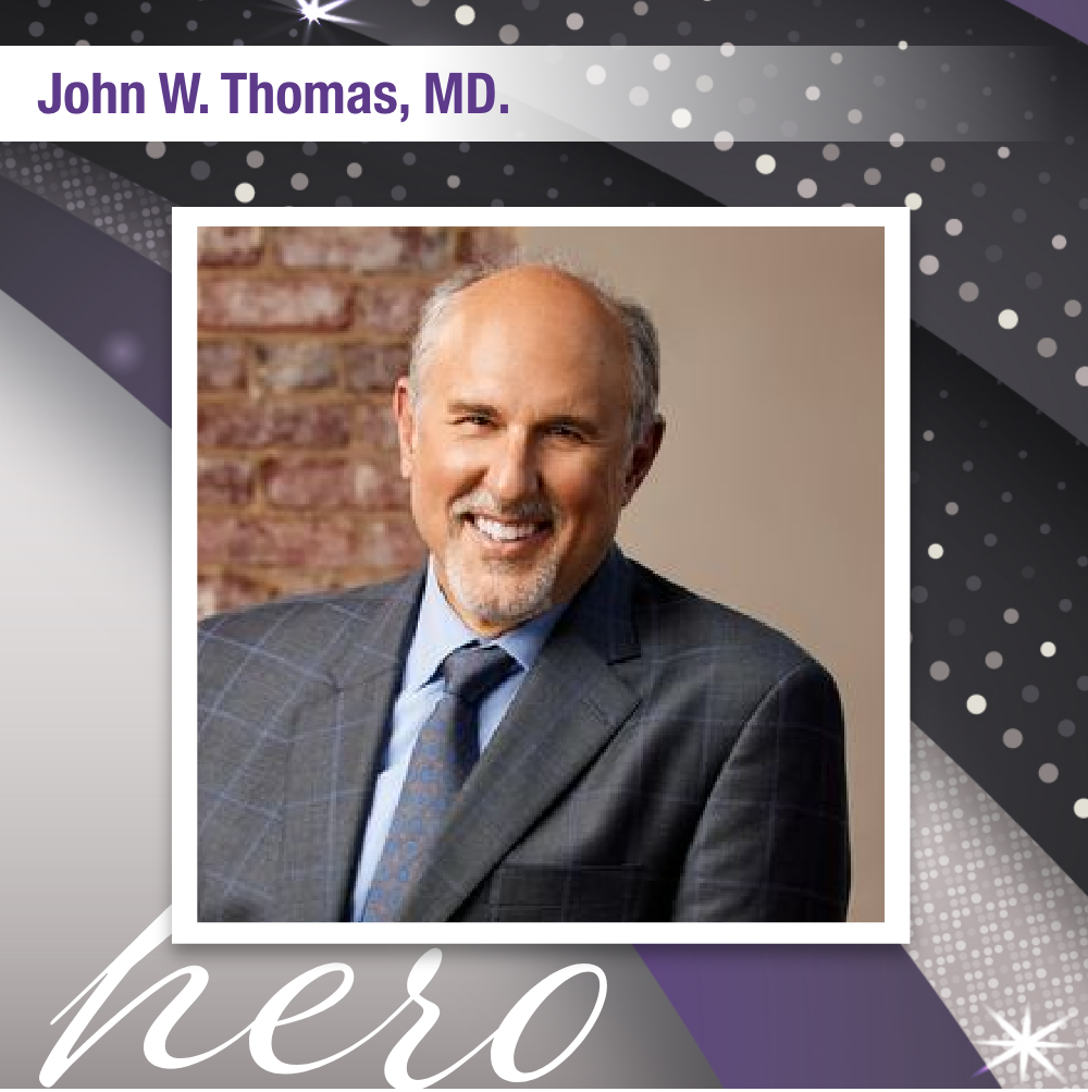 Photo of John W. Thomas, MD that reads "hero". He is smiling for a professional headshot and wearing a tuxedo.